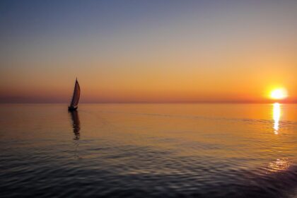 silhouette of sail boat on body of water